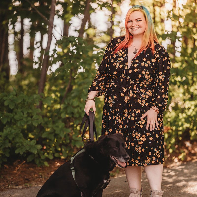 Alex in the woods with her dog