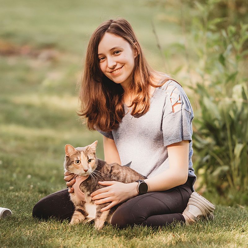Elle sitting in the grass with her cat