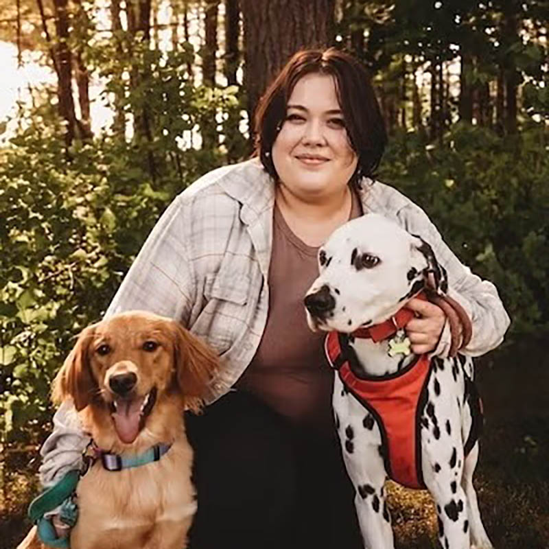 Elliot with her two dogs in the woods