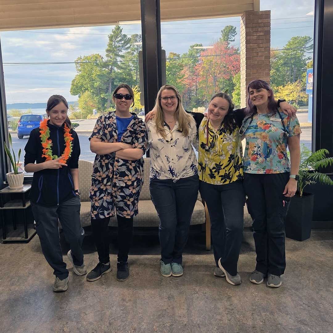 staff wearing fun Hawaiian shirts posing for a photo in the lobby
